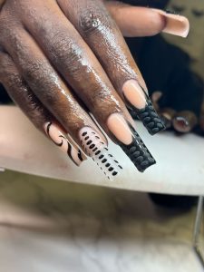 Bonner completes a black, clear color nail set with swirls, dots and a matte design for one of her clients on Jan. 20, 2023. (Photo/Aireeyce Bonner)