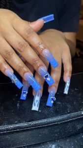 Nail Technician Kailey Williams poses her clients’ long, custom-designed and powdered nails on Feb. 3. (Photo/Kailey Williams)