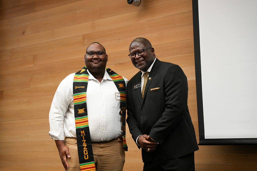 KC Scholar Roman Leaphart who is graduating with his degree in Secondary English Education stands by CASE Director Dr. Andre Thorn for a photo after receiving the Kente Stole. (CASE photos/Braiden Wade)